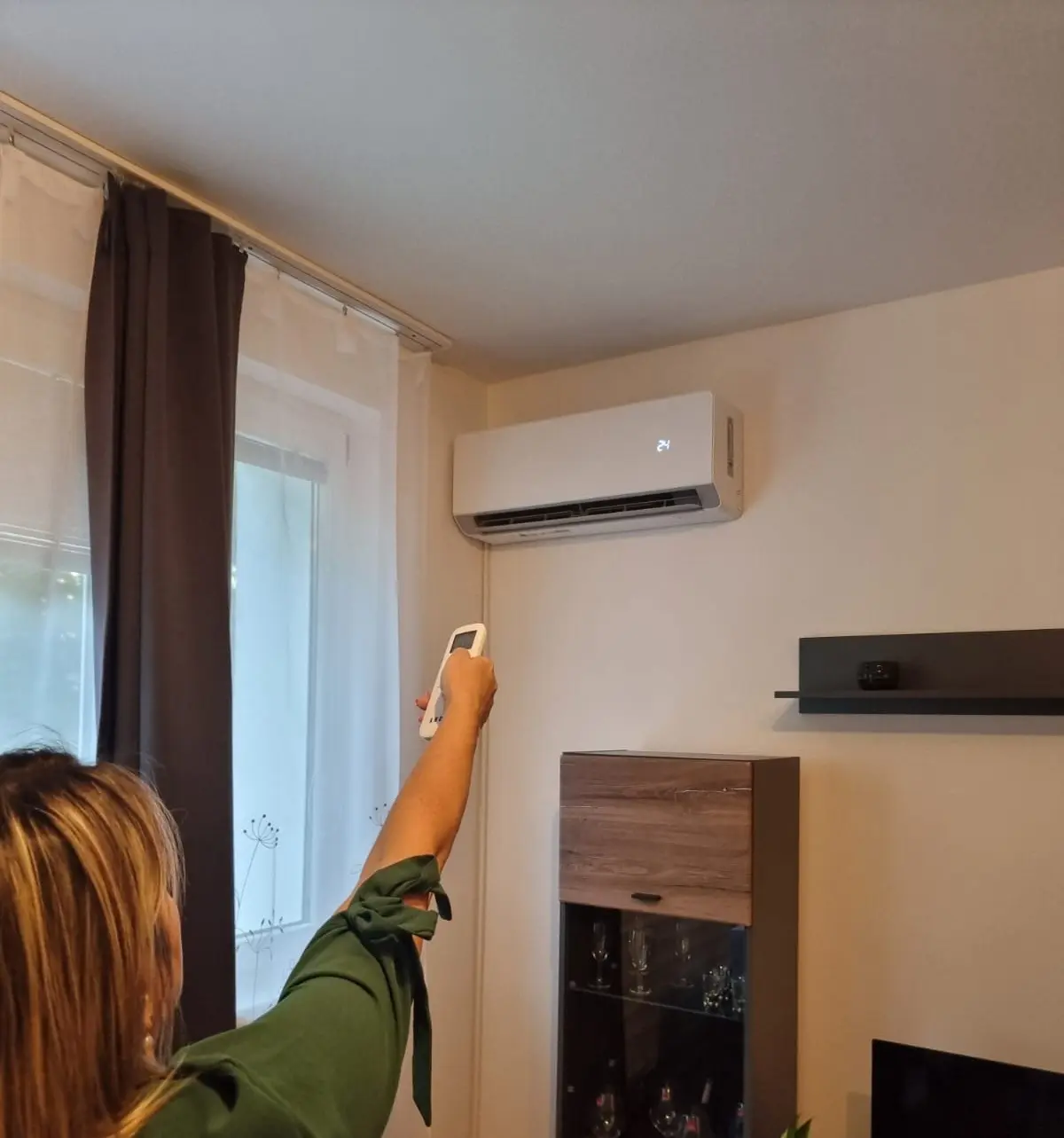 Žena zapínajúca klimatizáciu