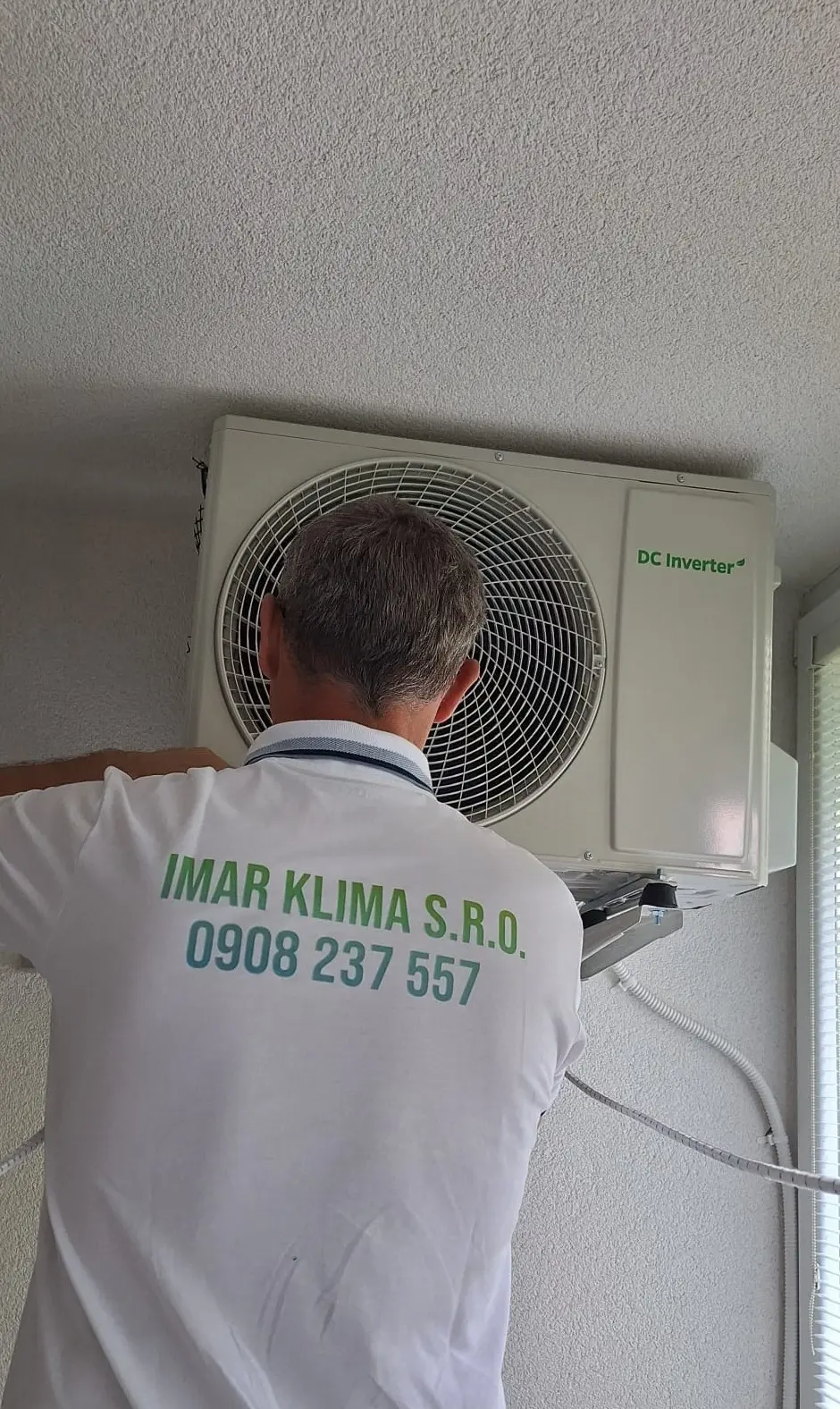 Servisný technik opravujúci vonkajšiu jednotku klimatizácie